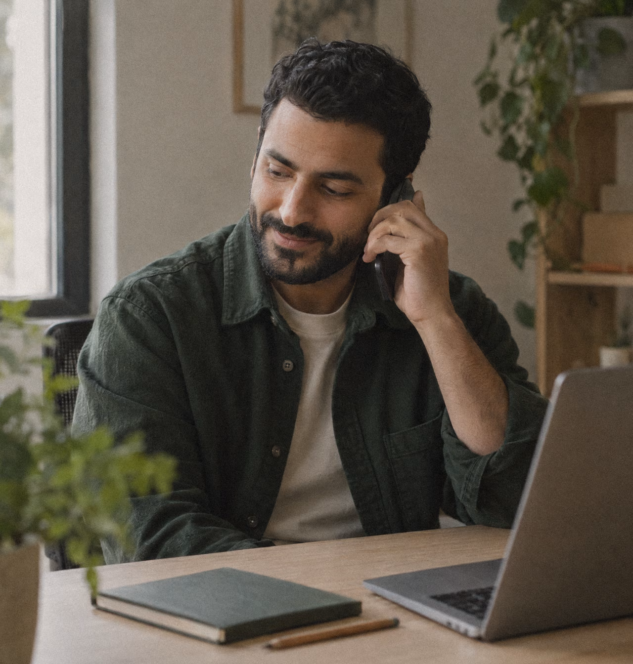 Small-business owner on a relaxed phone call at his desk.